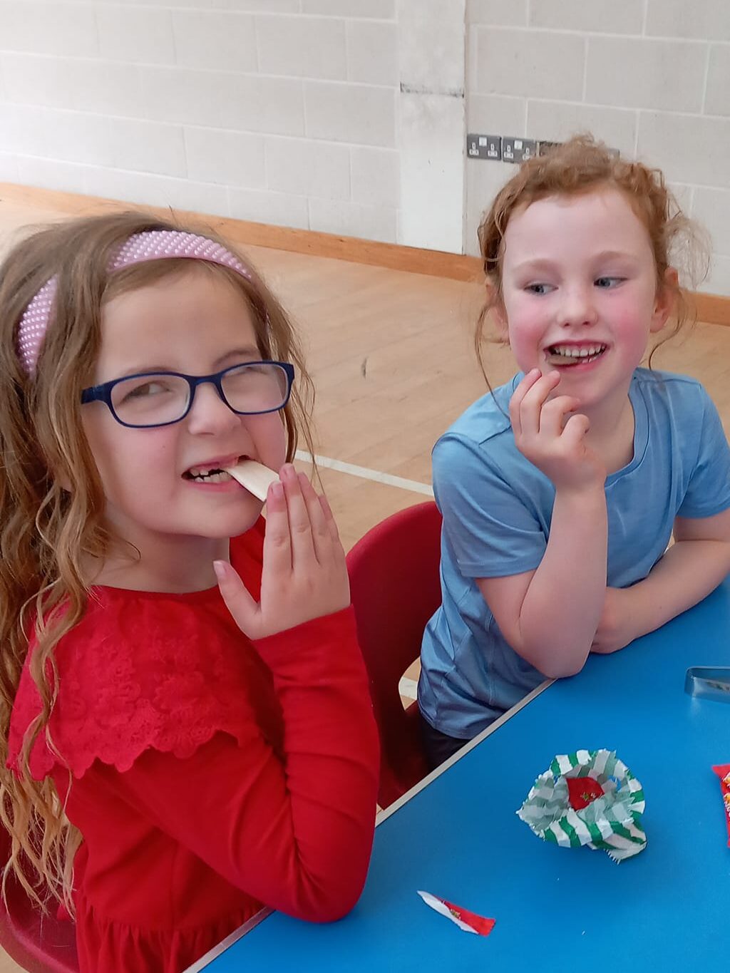 This image shows two girls helping themselves at the pick and mix sweet table at the Angel Eyes Musical Tots Family Day